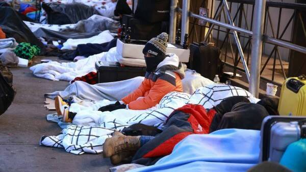 Противостояние в гостиницах Нью-Йорка утихает, так как некоторые мигранты соглашаются на койки в бруклинском мега-приюте в условиях низких температур