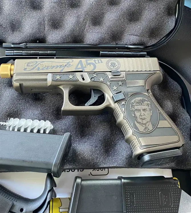 Без стыда Дональд Трамп сияет, держа пистолет с выгравированным на рукоятке лицом!